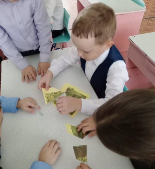 дети собирают пазл на парте